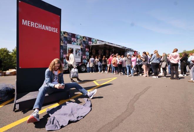 Carol Sullivan of Chicago takes a photo of her new shirt as thousands of Taylor Swift fans line up to purchase merchandise outside Gillette Stadium on Thursday, May 18, 2023.