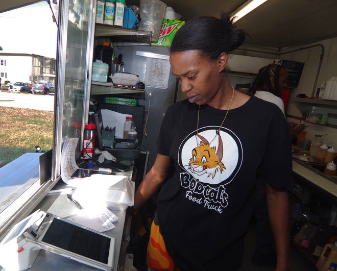 Kimyana Dardy of Dorchester, who serves as the Bobcats Food Truck cashier, server, and marketing director, goes over receipts in between customers on Friday, Nov. 3, 2023.
