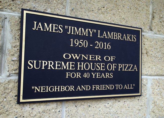 A plaque mounted on the wall of the Supreme House of Pizza in Brockton, dedicated to late founder and owner James Lambrakis, who took great pride in being a part of the community. Pictured Tuesday, Nov. 14, 2023.