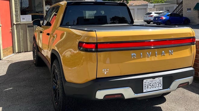 The rear of the Rivian R1T in compass yellow
