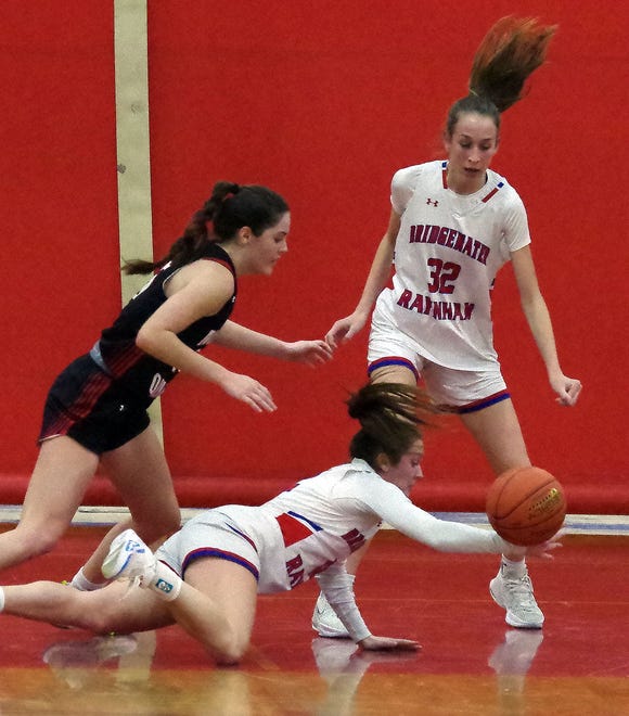 North Quincy's Ava Bryan (L), and Bridgewater-Raynham's Brenna Woodbury dive for a loose ball while Brenna's teammate Camden Strandberg watches during the game on Monday, Jan. 8, 2024.