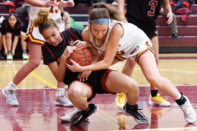 From left, New Heights Nevaeh Stephney and Cardinal Spellman's Makenzie Potter go after a loose ball during a game on Tuesday, Jan. 9, 2024.