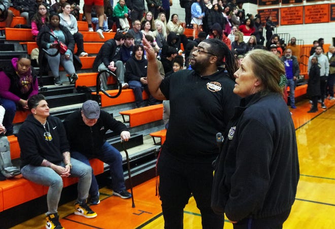 Avon athletic director and varsity basketball coach Mike Hayes and Avon school police officer Nancy Gjelsvick look into the stands to find the culprit responsible for throwing a water bottle onto the floor during the basketball game between visiting Holbrook and Avon on Wednesday, Jan. 10, 2024. The culprit was identified and asked to leave immediately.