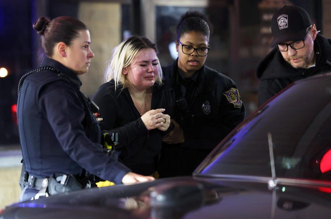 A woman who is visibly upset is escorted by Brockton police officers following a shooting inside the Hibachi Sushi Supreme Buffet, at 718 Crescent St. in Brockton, on Friday, Jan. 12, 2024.