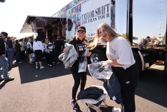 Elizabeth Rotondo of Brockton and her daughter Jamie Rotondo, 15, hold shirts as thousands of Taylor Swift fans line up to purchase merchandise outside Gillette Stadium on Thursday, May 18, 2023.