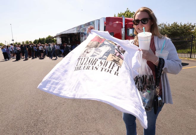 Kaitlinn Sweeney holds a shirt as thousands of Taylor Swift fans line up to purchase merchandise outside Gillette Stadium on Thursday, May 18, 2023.